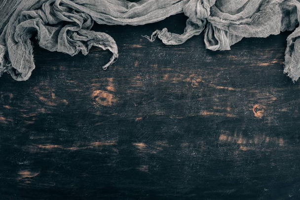 Old linen cloth on a black wooden background. Top view. Copy space for your text. - Valokuva, kuva