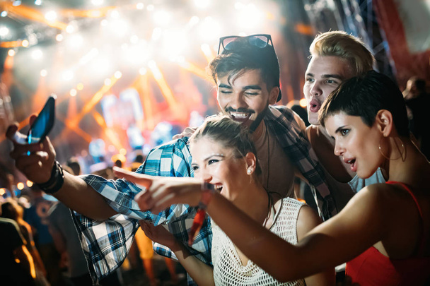 Happy young friends taking selfie at music festival - 写真・画像