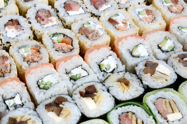 Zbliżenie: sporo sushi rolls z różnymi nadzieniami. Makro pchnięciu gotowane klasycznej kuchni japońskiej. Obraz tła - Zdjęcie, obraz