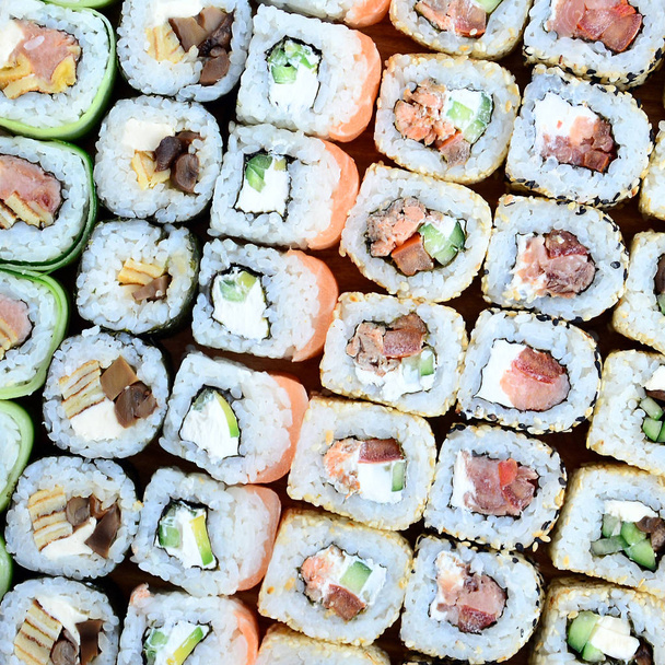 Detail hodně sushi rohlíky s různou náplní. Makro snímek klasického japonského pokrmu. Obrázek na pozadí - Fotografie, Obrázek