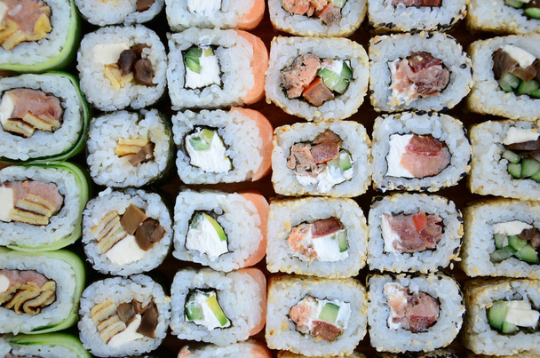 Крупным планом много суши-роллов с различными начинками. Макро-стопку классической японской кухни. Фоновое изображение
 - Фото, изображение