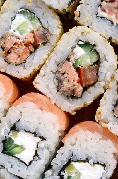 Close-up of a lot of sushi rolls with different fillings. Macro shot of cooked classic Japanese food. Background image - Photo, Image