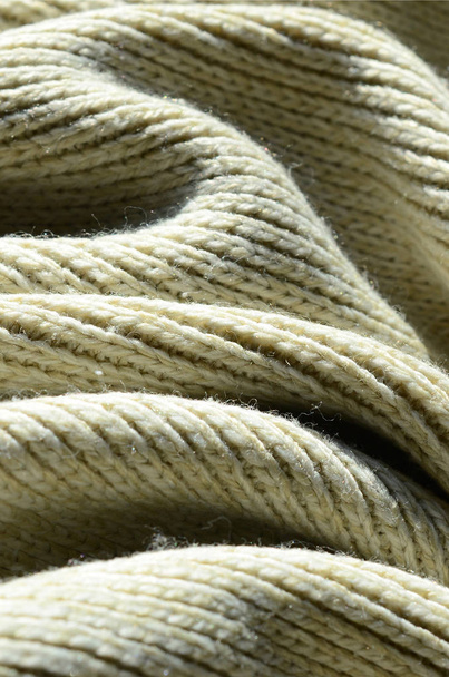 Fabric texture of a soft yellow knitted sweater. Macro image of the structure of bindings in yarns - Photo, image