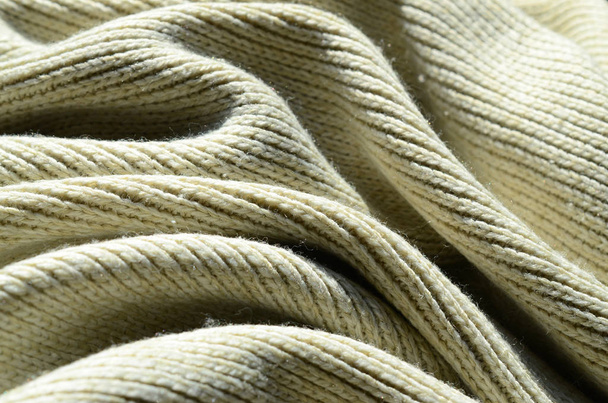 Fabric texture of a soft yellow knitted sweater. Macro image of the structure of bindings in yarns - Photo, Image