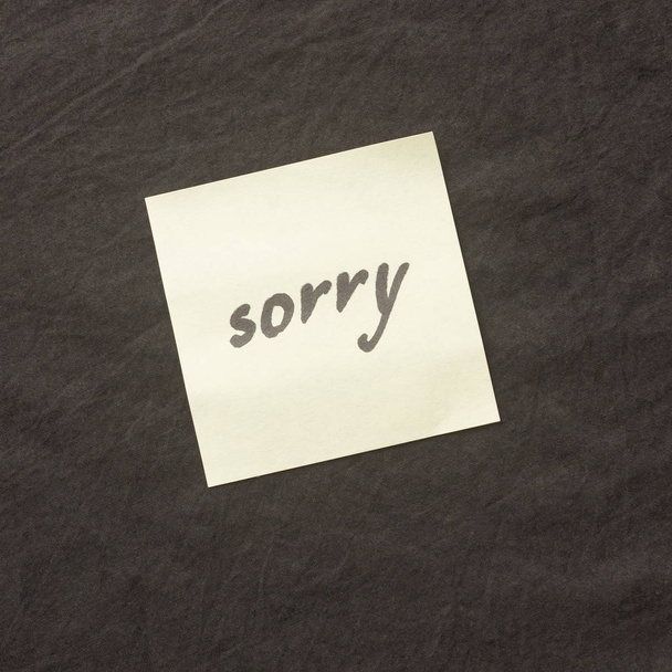暗い背景に手書きのメモ。残念な謝罪のメモ - 写真・画像