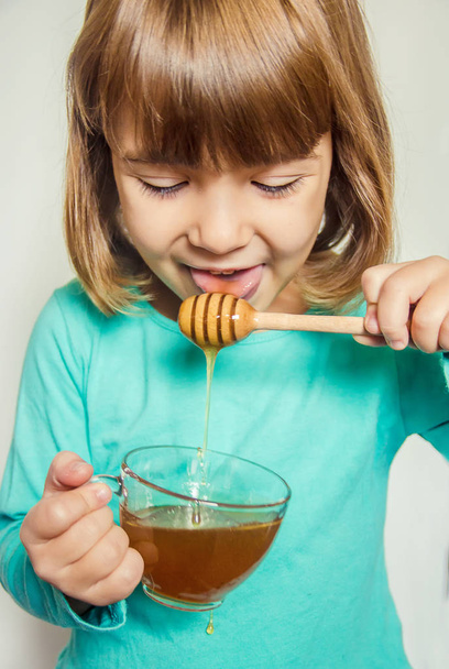 Ребенок ест мед. Селективный фокус
.  - Фото, изображение