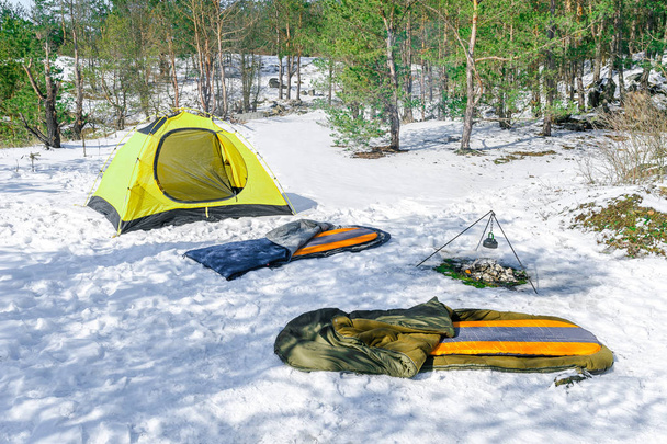Outdoor the sleeping pad and bag near yellow tent in winter - Photo, Image
