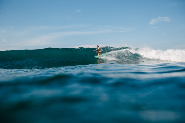 knappe man paardrijden golven op een surfplank terwijl het hebben van vakantie - Foto, afbeelding