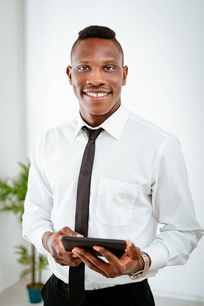 Jovem empresário africano segurando tablet digital e olhando para a câmera
 - Foto, Imagem