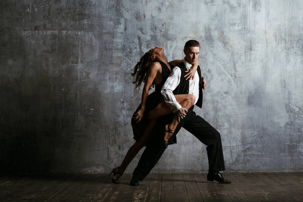 Jovem mulher bonita em vestido preto e homem dança tango
 - Foto, Imagem