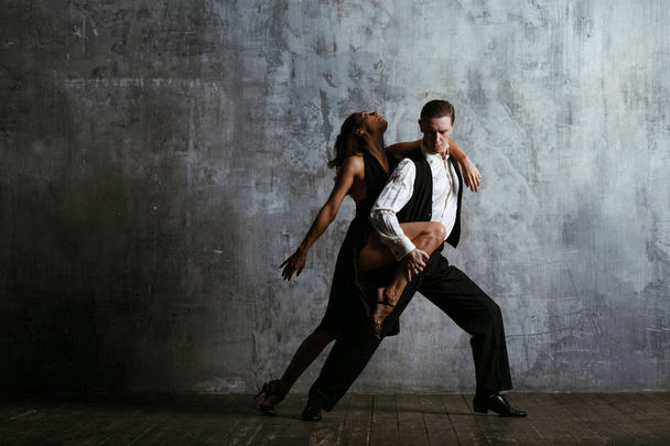 Fiatal csinos nő fekete ruha és a férfi tánc tangó - Fotó, kép