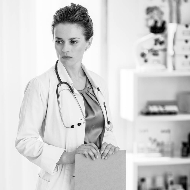 Thoughtful medical doctor woman with clipboard - Foto, Imagem
