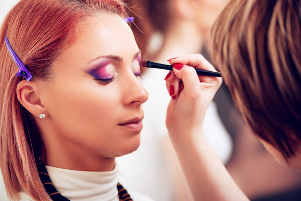 Makeup artist applying the eyeshadow to model - Photo, Image