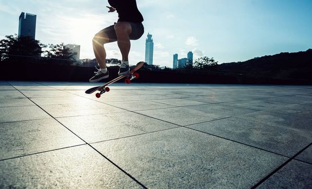 Skateboarder legs skateboarding at sunrise city  - Foto, Bild