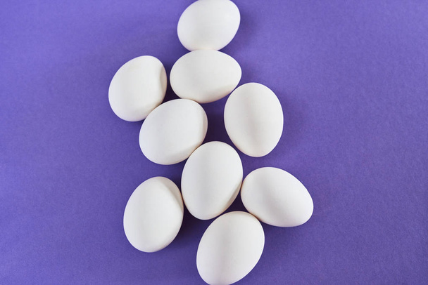 Top view of fresh white chicken eggs laying on purple background. - Φωτογραφία, εικόνα