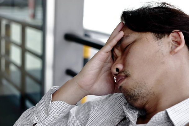 Ansioso y cansado hombre de negocios asiático en depresión con las manos en la frente en la oficina
 - Foto, Imagen