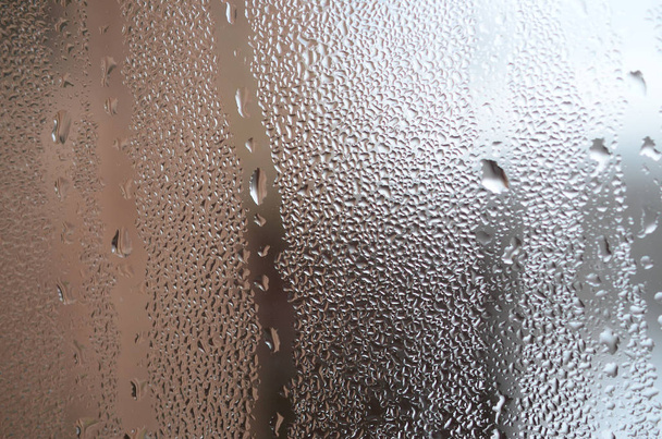 die Textur eines vernebelten Glases mit vielen Tropfen und Kondenswasser fließt. Hintergrundbild - Foto, Bild