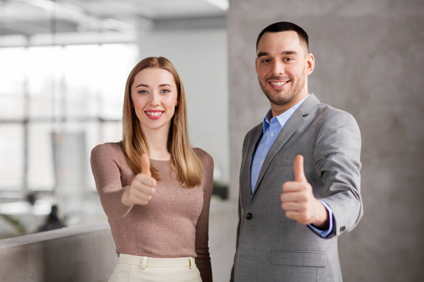 businesswoman and businessman showing thumbs up - Foto, Bild