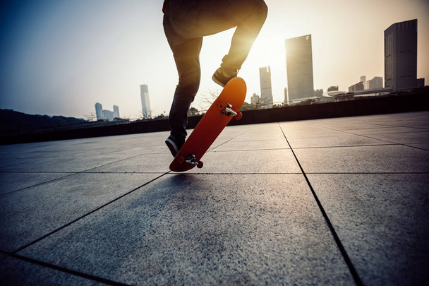 Skateboarder legs skateboarding at sunrise city - Foto, imagen