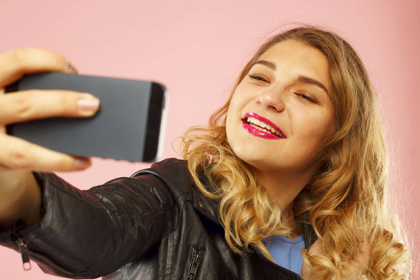 Portrait of a beautiful young woman making selfie on smart phone - 写真・画像