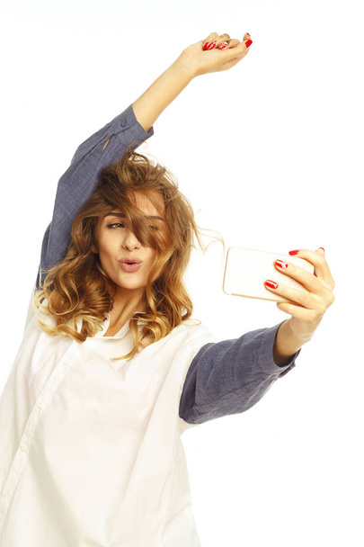 Portrait of a beautiful young woman making selfie on smart phone - Foto, Bild