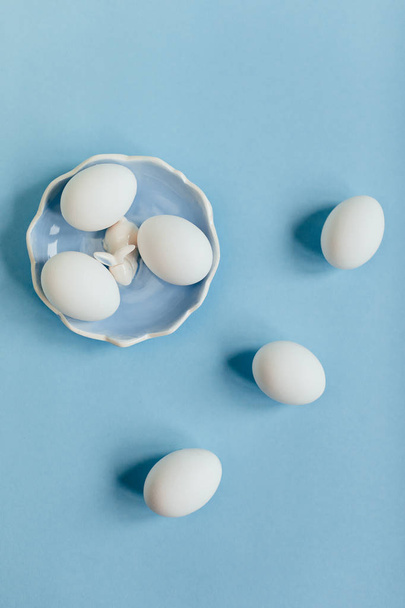 Velikonoční složení bílých vajec na modrá Keramická deska na modrém pozadí  - Fotografie, Obrázek