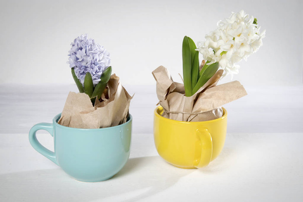 Flowers composition with lilac and white hyacinths wrapped in kraft paper in mug . Spring flowers on white background. Easter concept. - Foto, Imagem