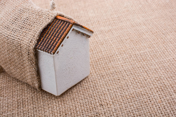 Tuvalin arka planında küçük bir model ev - Fotoğraf, Görsel