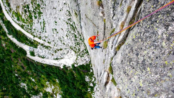 male rock climber on a hard and steep climbing route in the granite walls of the Val Bregaglia in Switzerland - Photo, Image