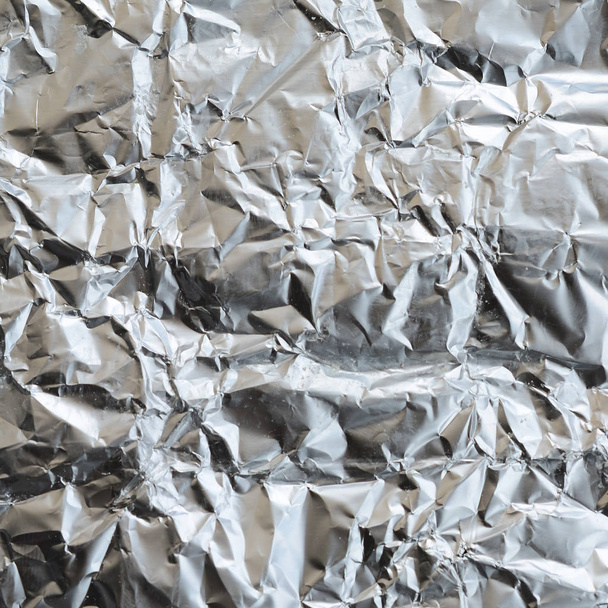Ezilmiş teneke alüminyum gümüş folyo arka plan doku için parlak buruşuk yüzeyli ince kırışık levha - Fotoğraf, Görsel