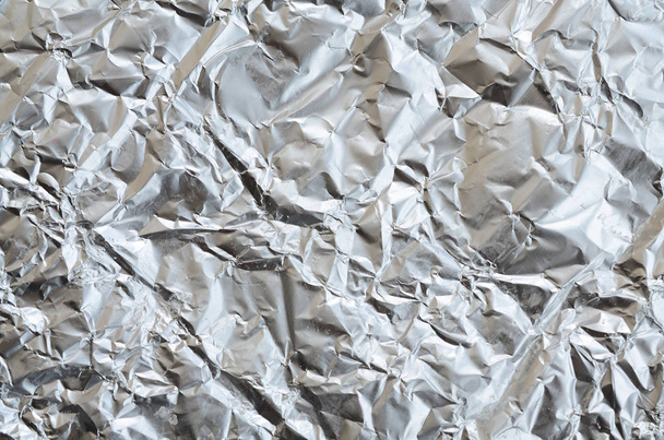 Tenké zmuchlaný list Drcený plechové hliníkové stříbrné fólie pozadí s lesklou zmačkaný povrch pro texturu - Fotografie, Obrázek