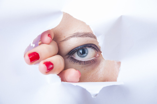 Woman looking through paper hole - Photo, image