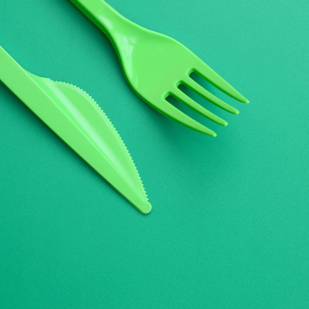 Cubertería de plástico desechable verde. Tenedor de plástico y cuchillo se encuentran en
  - Foto, Imagen