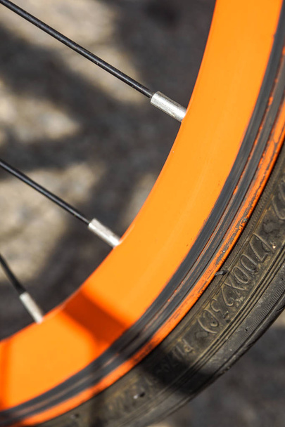 Велосипедне колесо старого помаранчевого кольору крупним планом
 . - Фото, зображення