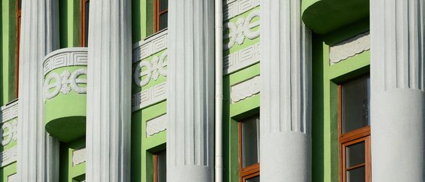 Odnowiony stary Budynek wielokondygnacyjny antyczne kolumny, malowane w kolorze zielonym - Zdjęcie, obraz