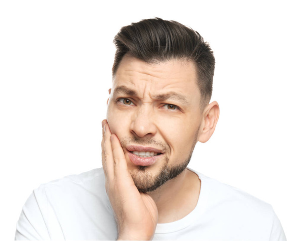 Young man suffering from toothache on white background - Foto, Imagen