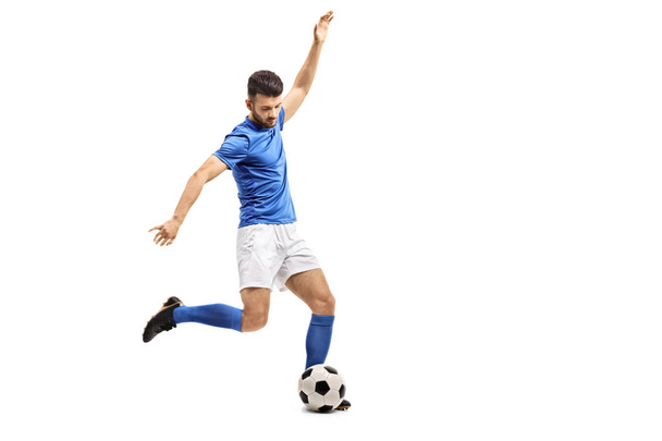 Soccer player kicking a football isolated on white background - Φωτογραφία, εικόνα