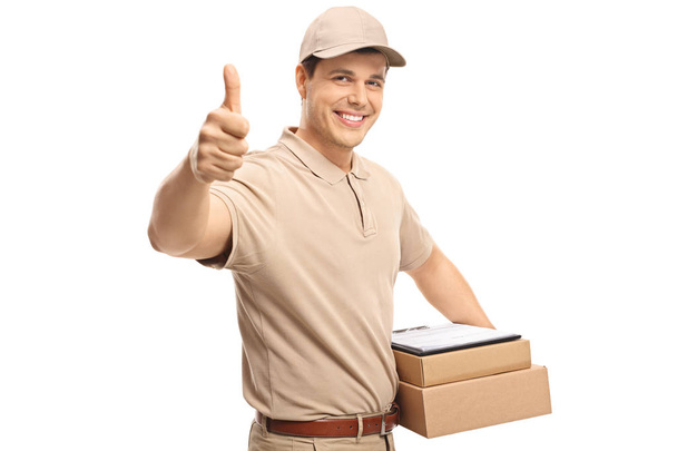 Delivery man making a thumb up sign isolated on white background - Fotó, kép