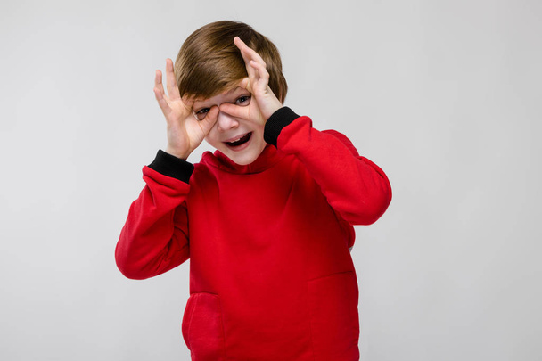 Kedves preteen kaukázusi fiú alkalmi ruhát mutatja a különböző kifejezések fehér falon a stúdió. - Fotó, kép