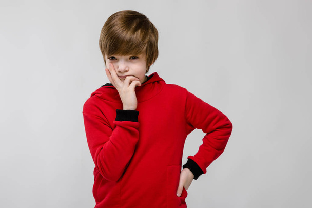 Nice preteen caucasian boy in casual outfit showing different expressions on white wall in studio. - Photo, Image