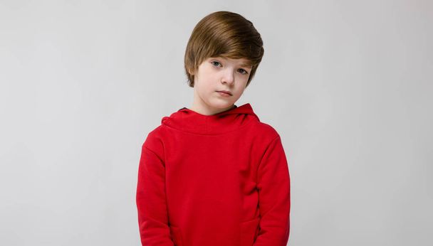 Nice preteen caucasian boy in casual outfit showing different expressions on white wall in studio. - Photo, Image