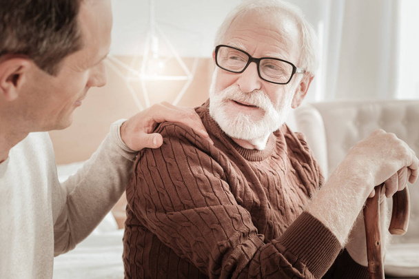 Bespectacled attentive man sitting and listening to his son. - 写真・画像