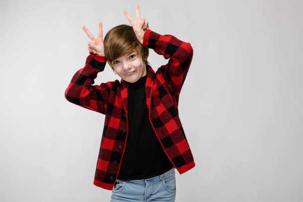 Nice preteen caucasian boy in casual outfit showing different expressions on white wall in studio. - 写真・画像