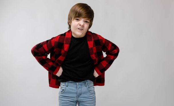 Nice preteen caucasian boy in casual outfit showing different expressions on white wall in studio. Argue with hands on waist. - Photo, Image