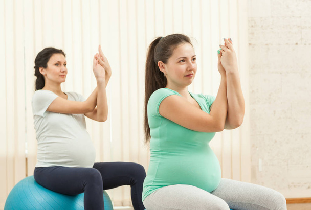 Beautiful pregnant women doing yoga on the balls in the gym - Foto, Imagem