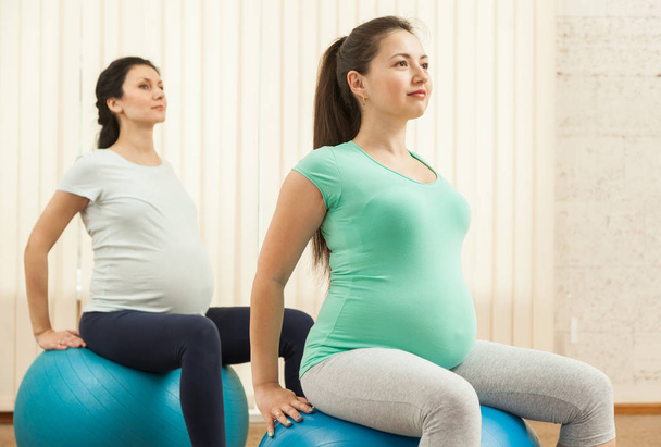 Beautiful pregnant women doing yoga on the balls in the gym - Φωτογραφία, εικόνα
