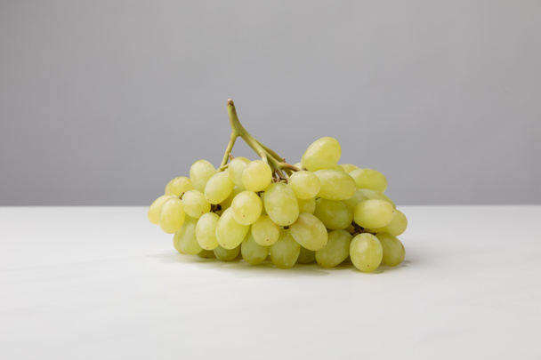 Vista de perto de pilha de uvas brancas em cinza
  - Foto, Imagem