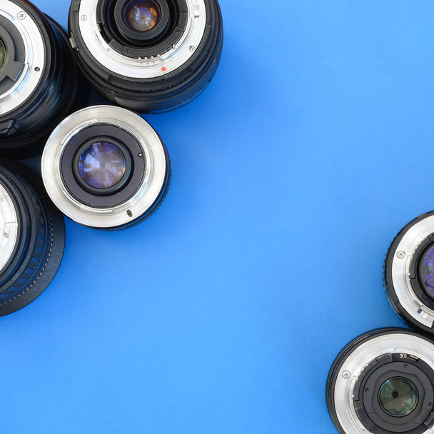 Várias lentes fotográficas repousam sobre um fundo azul brilhante. Espaço para texto
 - Foto, Imagem