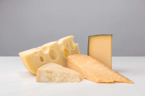 Closeup view of different types of cheese on gray - Zdjęcie, obraz