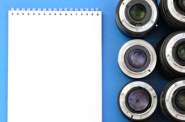 Birkaç fotoğraf lensler ve beyaz dizüstü parlak mavi bir arka plan üzerinde yalan. Metin için yer - Fotoğraf, Görsel